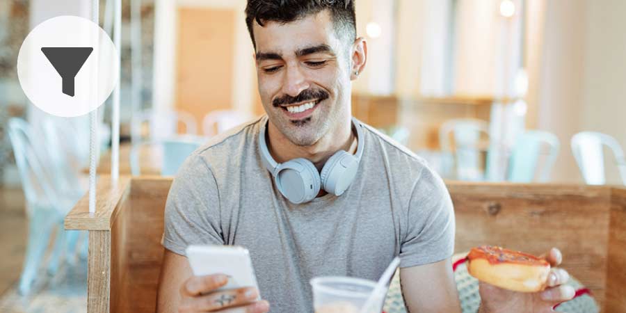Handsome buff man smiling at a message on his phone.
