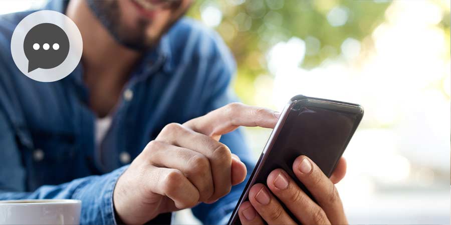 Man with beard sending a message on his mobile.