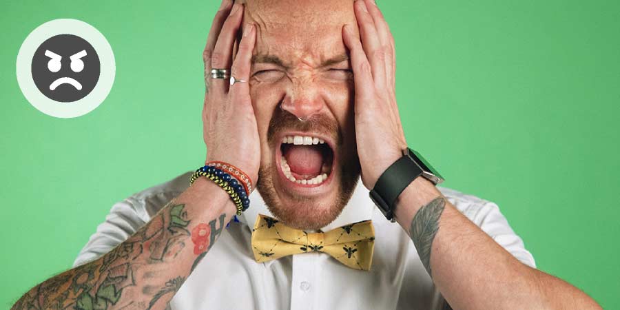 Mature man wearing bowtie screaming in frustration.