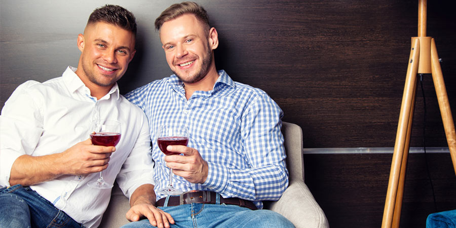 Two gay men sharing a glass of wine on a date